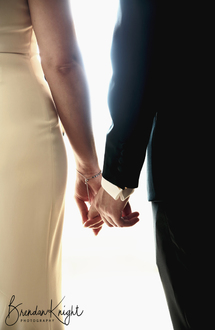 close up of bride and groom holding hands