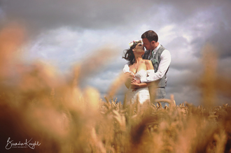 bride and groom kissing in wheat field